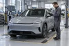Un technicien inspecte un véhicule électrique générique sur un banc de contrôle qualité.