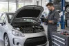 Un mécanicien diagnostique le moteur d’une citadine essence générique immobilisée en atelier.